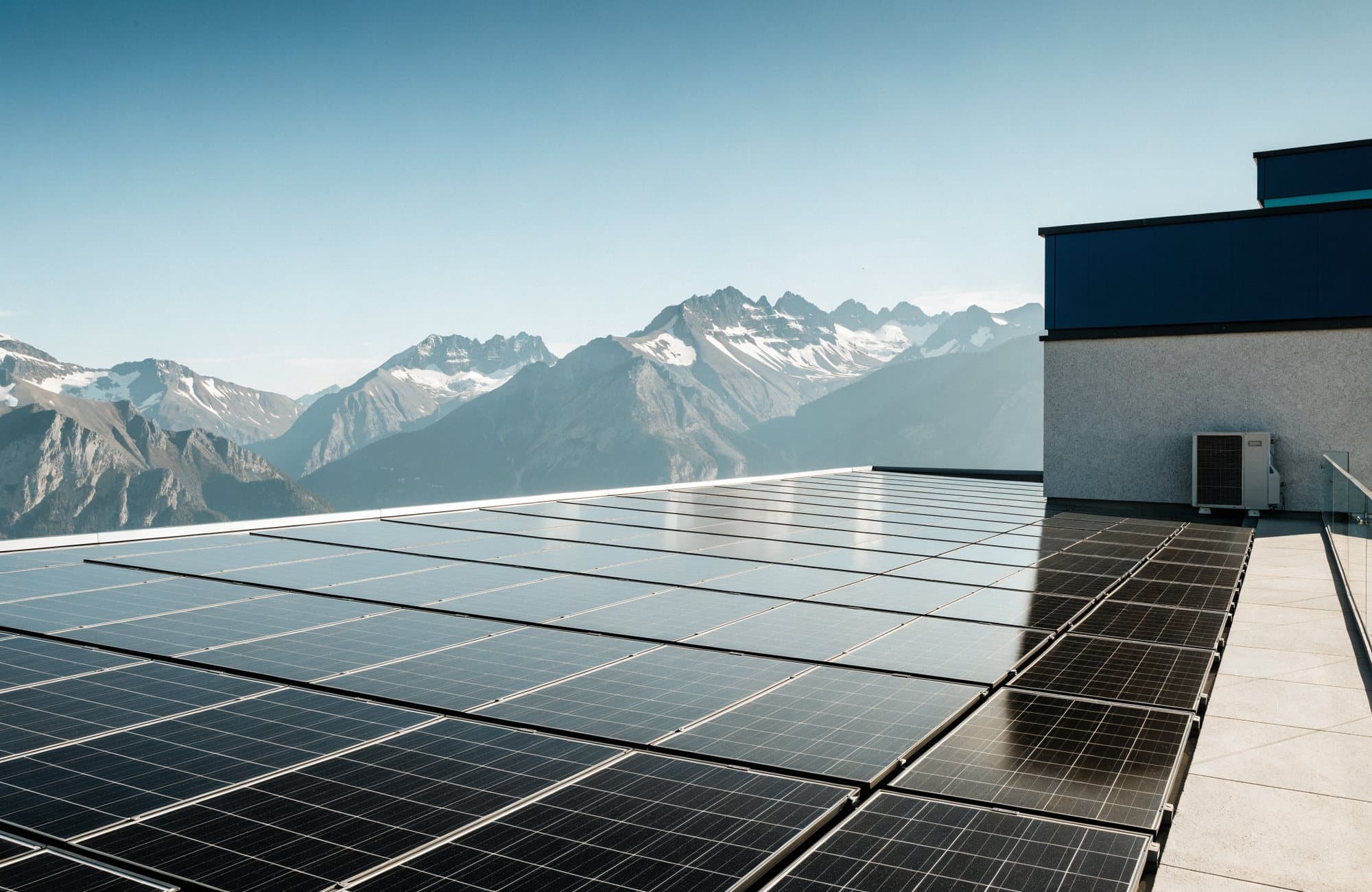 Toiture d’immeuble alpin équipée de panneaux photovoltaïques et d’une pompe à chaleur